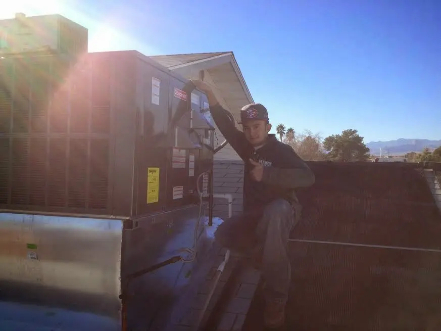 HVAC technician performing AC Tune-Up on a rooftop unit in Flatwoods